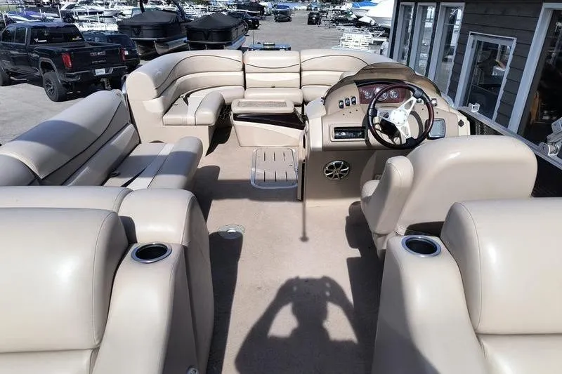 Slide: The Image of Interior of a 2010 Bennington 2250GCW pontoon boat with beige seating and steering console. - 2