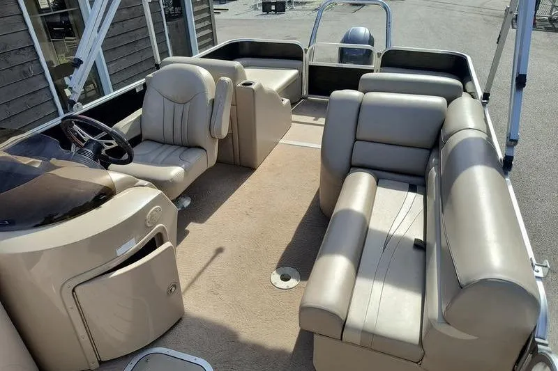 Slide: The Image of 2010 Bennington 2250GCW pontoon boat interior with beige seating and steering console. - 3
