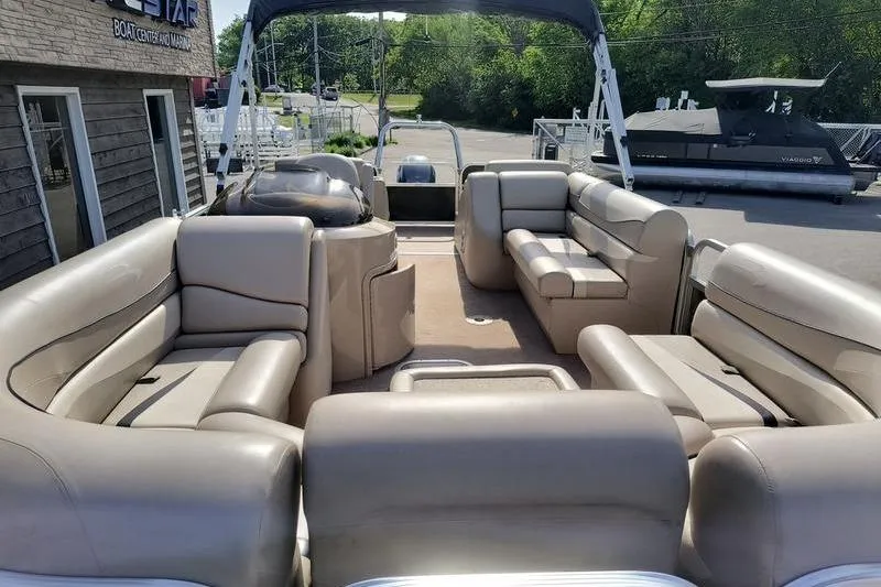 Slide: The Image of 2010 Bennington 2250GCW pontoon boat with spacious seating and canopy, docked at marina. - 5