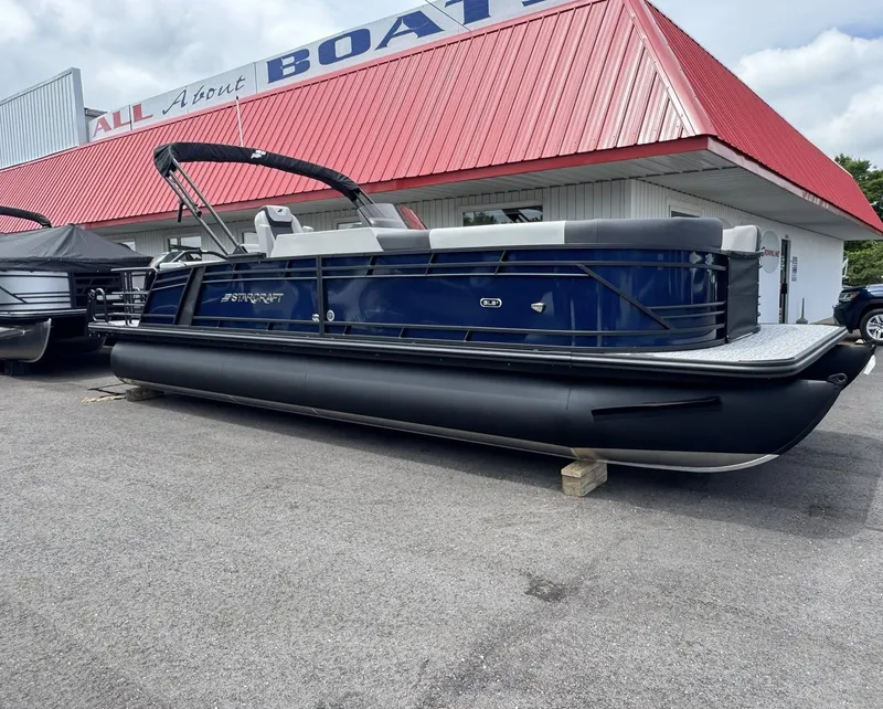 Slide: The Image of 2026 Starcraft SLS-5 Q DH pontoon boat outside a boat dealership. - 9