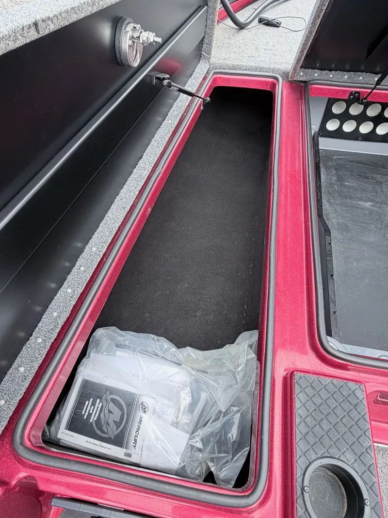 Slide: The Image of 2017 Triton 19 TrX boat storage compartment with manual and accessories. - 16