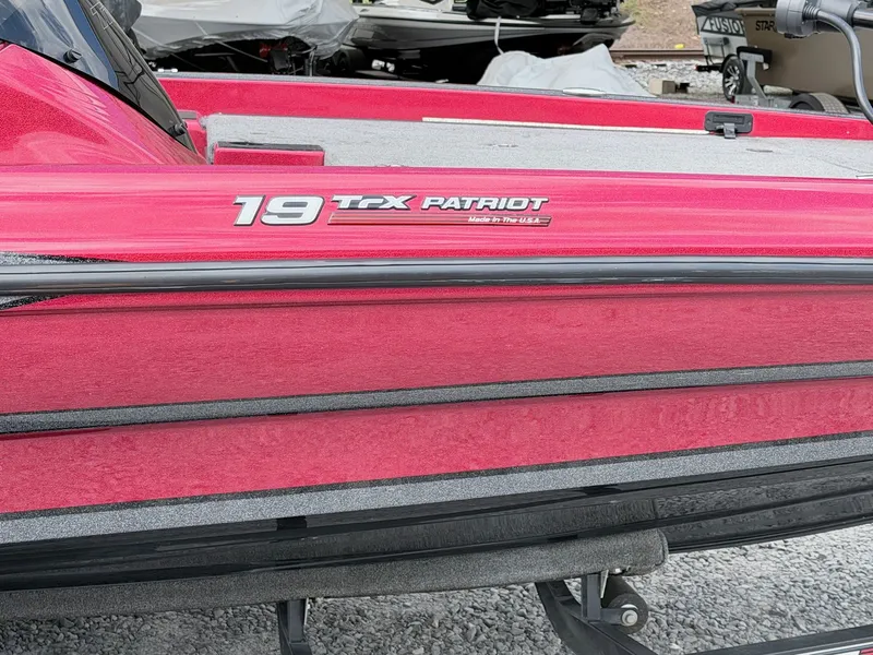 Slide: The Image of Red 2017 Triton 19 TrX Patriot boat side view. - 17