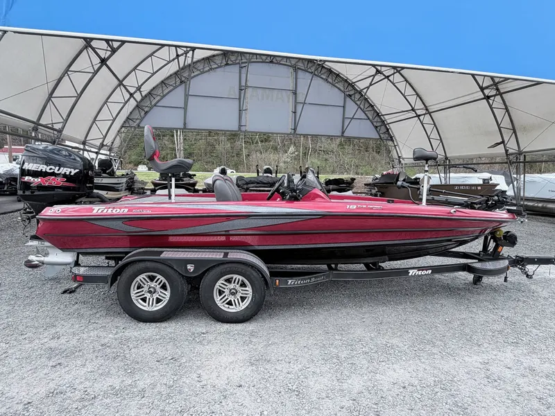 Slide: The Image of 2017 Triton 19 TrX boat on trailer under canopy. - 26