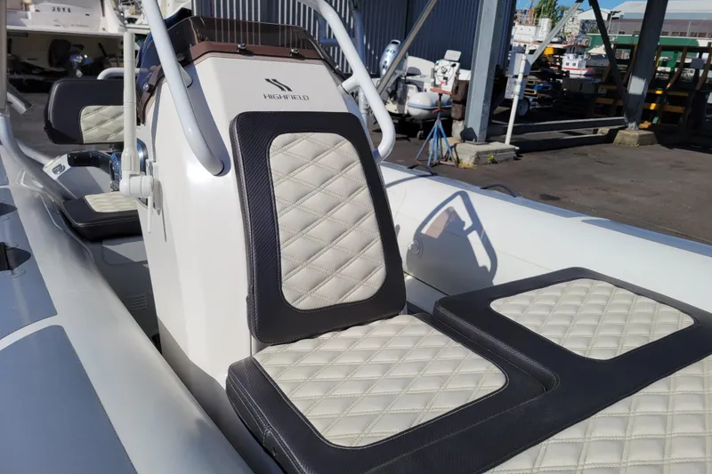 Slide: The Image of 2022 Highfield Sport 460 boat with quilted seating, docked outdoors. - 14