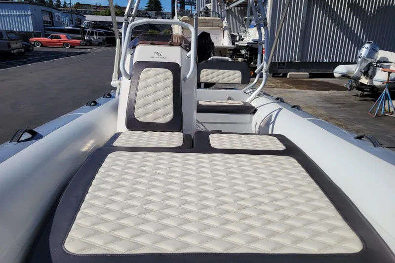 Slide: The Image of 2022 Highfield Sport 460 boat with quilted seating, docked outdoors. - 15