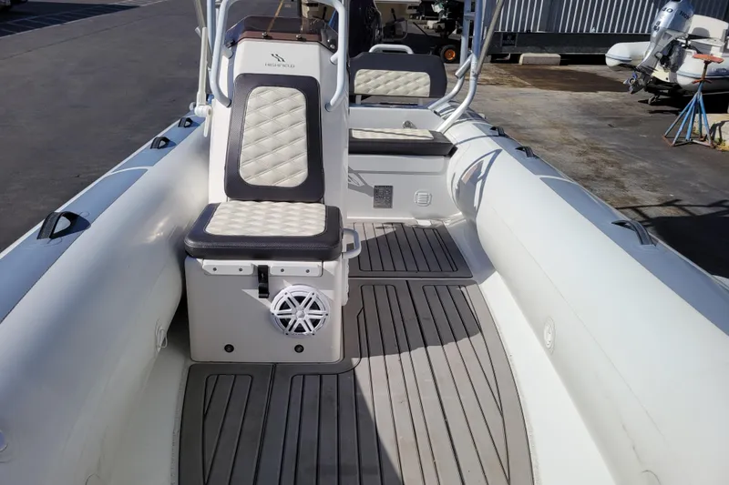 Slide: The Image of 2022 Highfield Sport 460 boat interior with cushioned seating and deck flooring. - 16