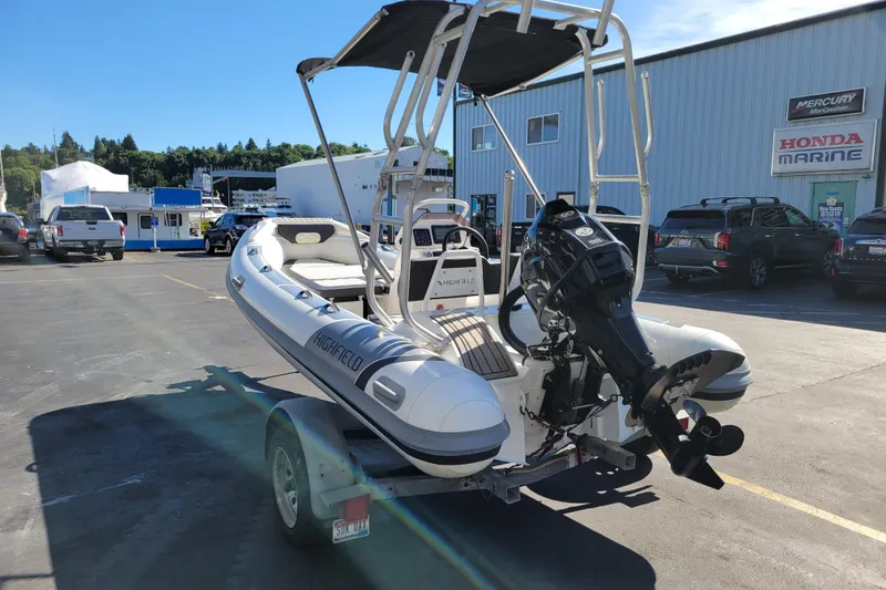 Slide: The Image of 2022 Highfield Sport 460 inflatable boat on trailer, parked at marine dealership. - 2