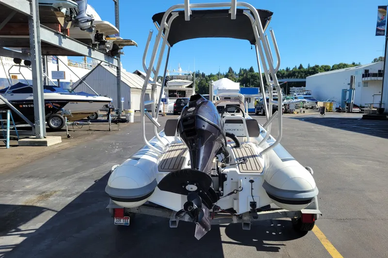 Slide: The Image of 2022 Highfield Sport 460 boat with outboard motor in a marina setting. - 3