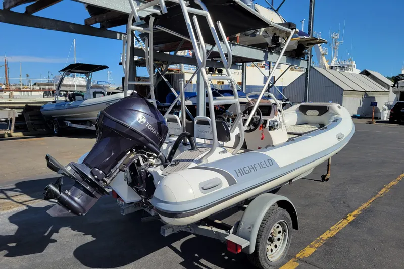 Slide: The Image of 2022 Highfield Sport 460 boat with Tohatsu engine on trailer at marina. - 4