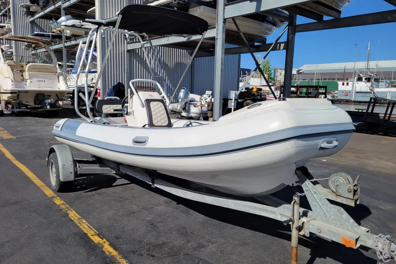Slide: The Image of 2022 Highfield Sport 460 boat on trailer at marina, featuring sleek design and modern amenities. - 6