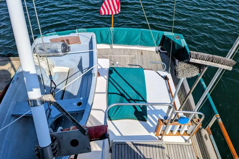 Slide: The Image of 1979 Grand Banks 42 Classic yacht deck with American flag and cleaning tools. - 10