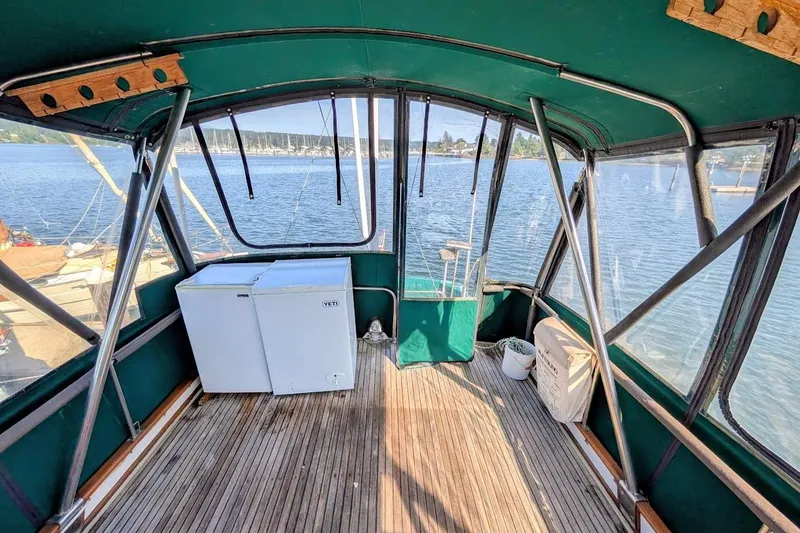 Slide: The Image of Interior view of 1979 Grand Banks 42 Classic boat with wooden flooring and green canopy. - 16