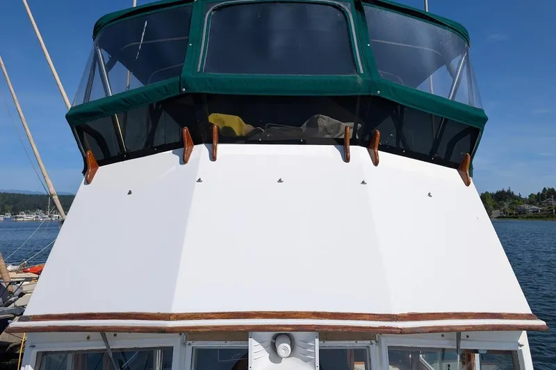 Slide: The Image of 1979 Grand Banks 42 Classic boat with green canopy, docked on a sunny day. - 19