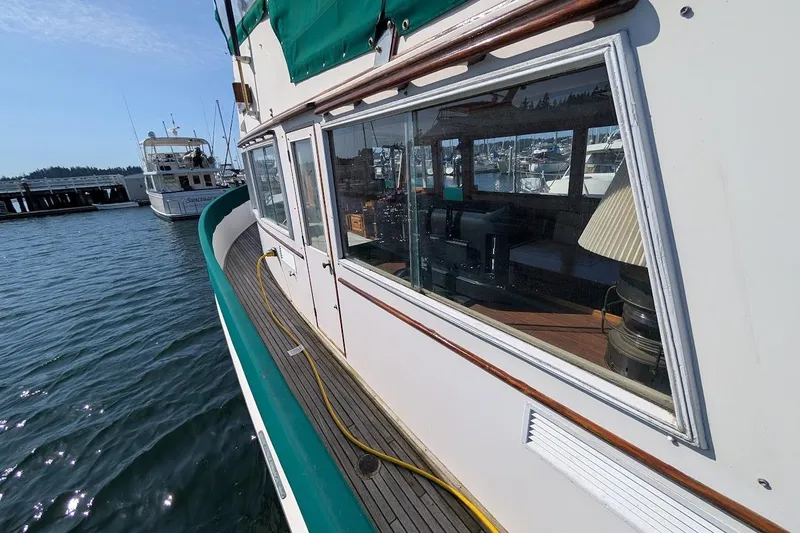 Slide: The Image of 1979 Grand Banks 42 Classic yacht docked, showcasing exterior and interior through large windows. - 21