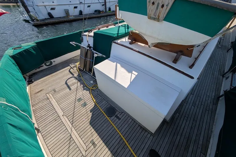 Slide: The Image of 1979 Grand Banks 42 Classic yacht deck with green covers and wooden flooring. - 24