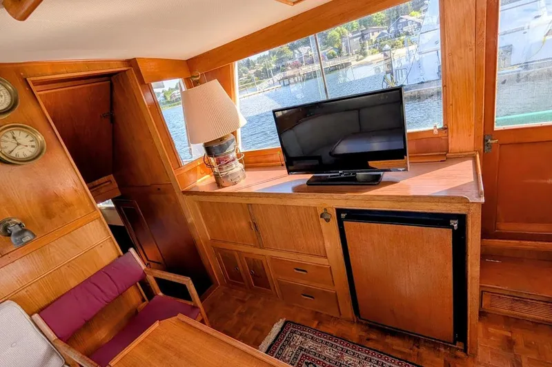 Slide: The Image of Interior of 1979 Grand Banks 42 Classic yacht with wood paneling, TV, and scenic window view. - 29