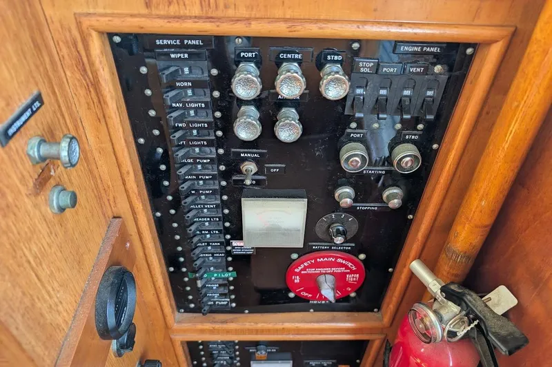 Slide: The Image of Control panel of a 1979 Grand Banks 42 Classic boat with switches and fire extinguisher. - 37