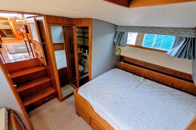 Slide: The Image of 1979 Grand Banks 42 Classic yacht interior with cozy bedroom and wooden furnishings. - 43