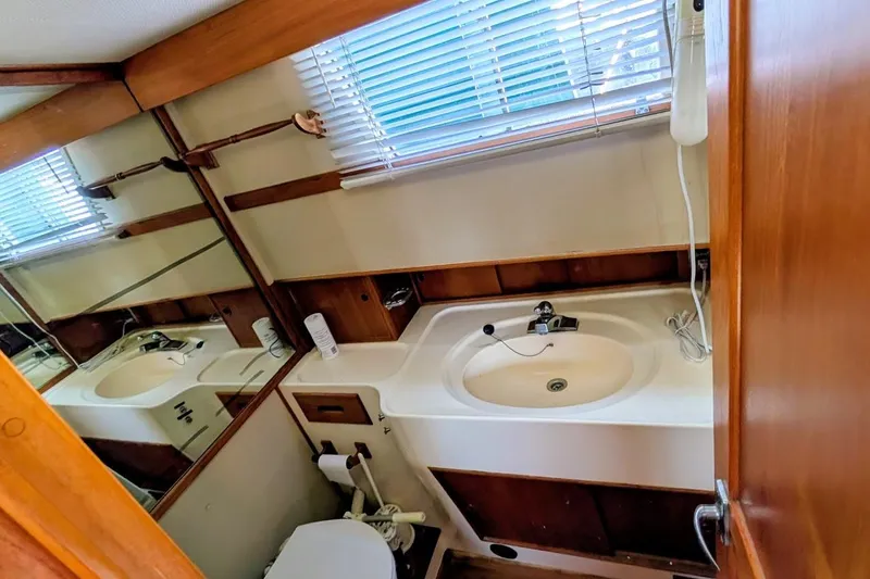 Slide: The Image of 1979 Grand Banks 42 Classic yacht bathroom with sink, mirror, and toilet. - 45