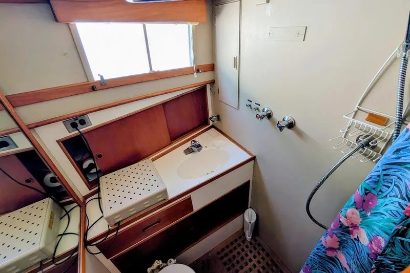 Slide: The Image of 1979 Grand Banks 42 Classic yacht bathroom with sink, shower, and wooden cabinetry. - 48