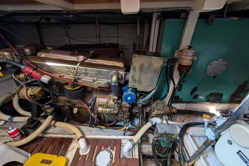 Slide: The Image of Engine room of a 1979 Grand Banks 42 Classic boat, featuring a Ford Lehman diesel engine. - 51