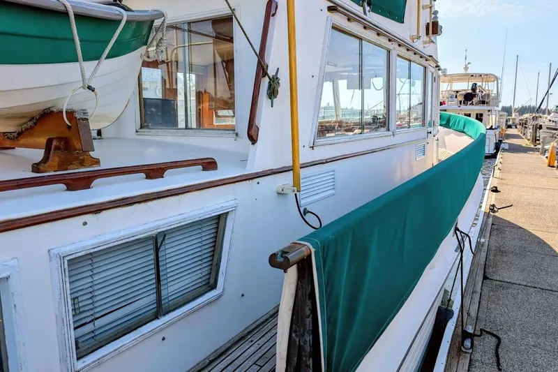 Slide: The Image of 1979 Grand Banks 42 Classic yacht docked, featuring green canvas covers and wooden accents. - 6