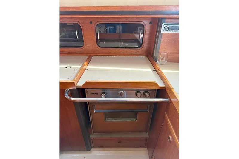 Slide: The Image of 1982 C&C Landfall 38 yacht galley with stove and wooden cabinetry. - 12