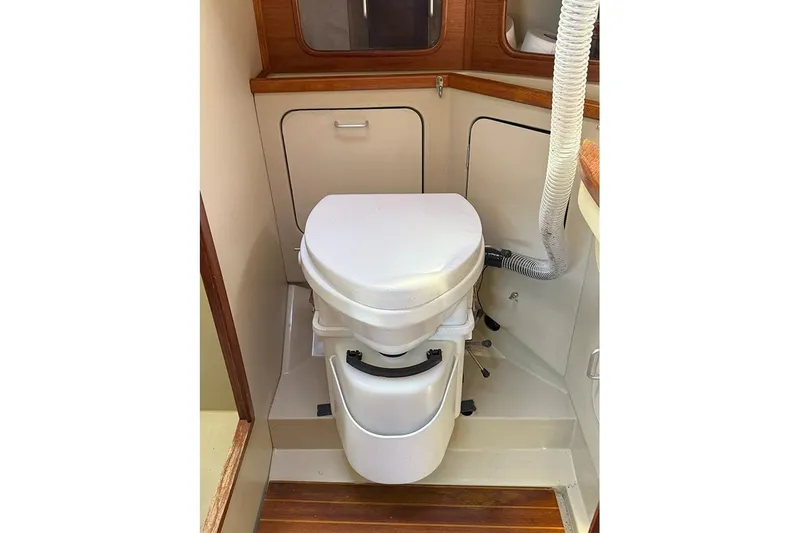Slide: The Image of 1982 C&C Landfall 38 yacht bathroom with compact marine toilet and wooden accents. - 14