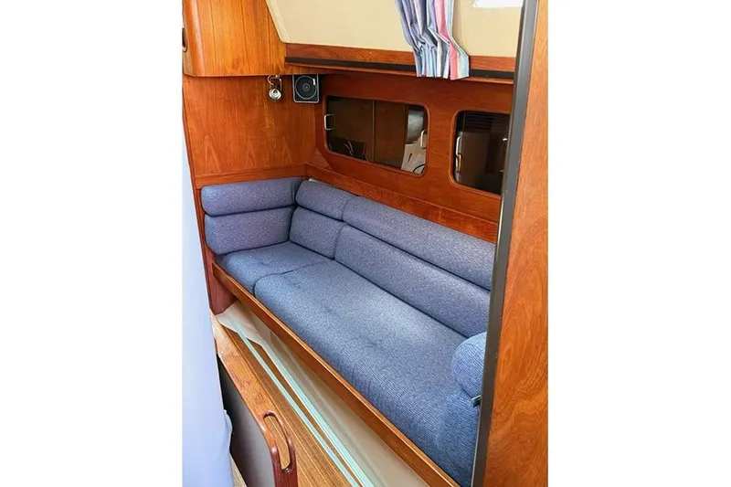Slide: The Image of Interior of 1982 C&C Landfall 38 sailboat with blue cushioned seating and wooden paneling. - 8