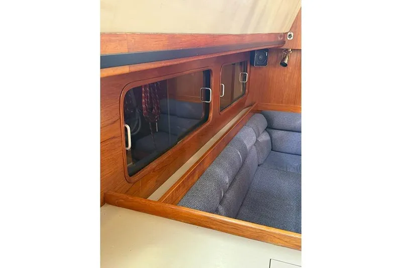 Slide: The Image of Interior of 1982 C&C Landfall 38 sailboat with wooden paneling and blue cushioned seating. - 9