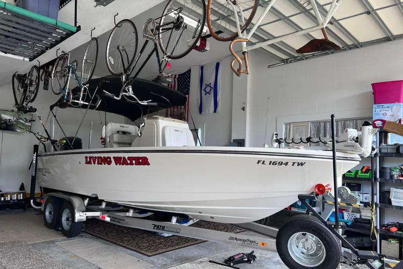 Slide: The Image of 2024 Pathfinder 2400 Open boat on trailer in garage with bicycles overhead. - 3