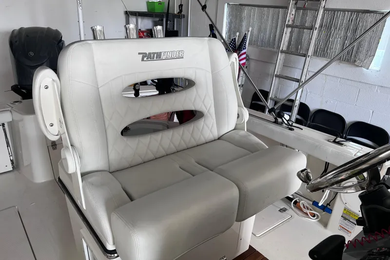 Slide: The Image of 2024 Pathfinder 2400 Open boat interior with white cushioned seating and steering wheel. - 5