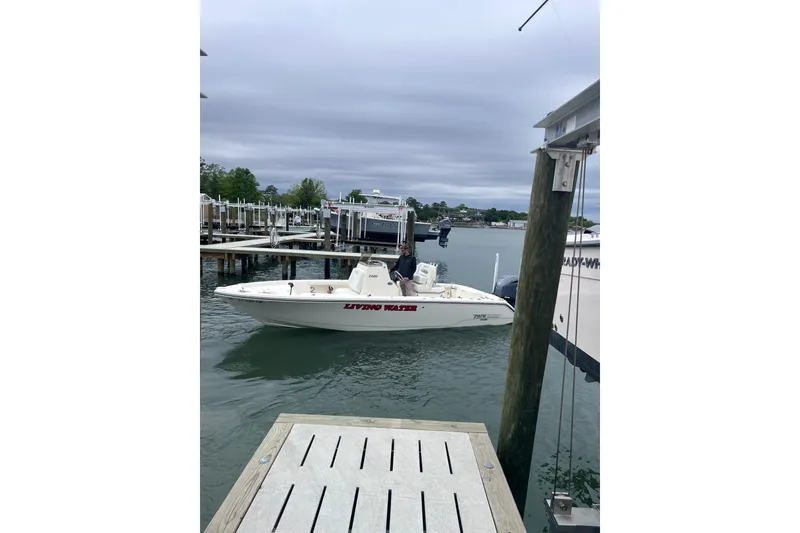 Slide: The Image of 2024 Pathfinder 2400 Open boat docked at marina under cloudy sky. - 6