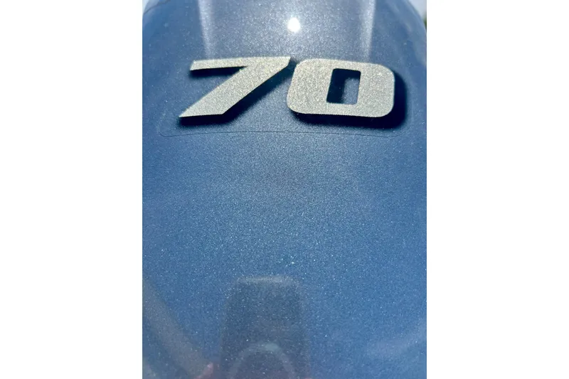 Slide: The Image of Blue surface with metallic "70" emblem, likely on a 2019 Alumacraft Classic 165 Sport. - 15