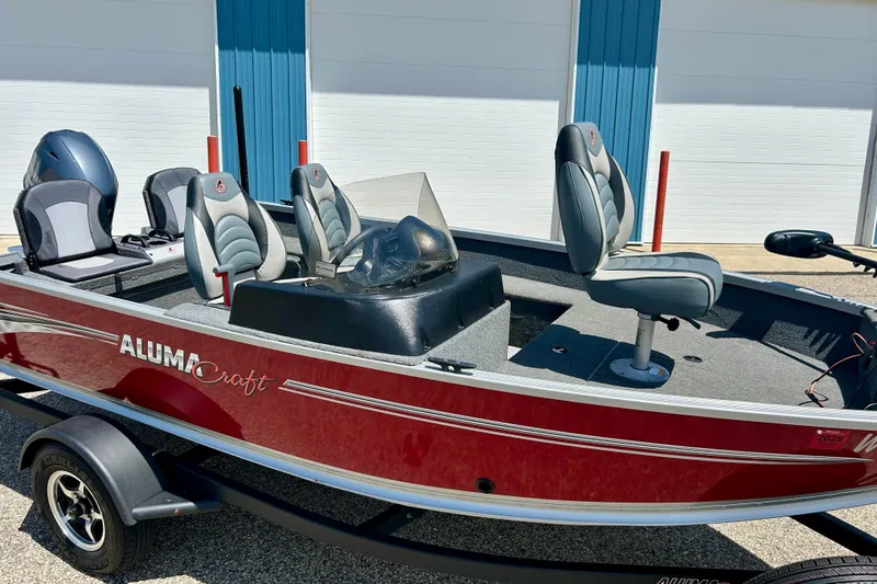 Slide: The Image of 2019 Alumacraft Classic 165 Sport boat with red exterior and comfortable seating. - 2