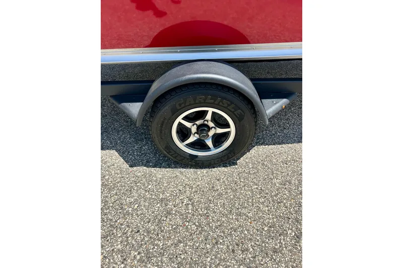 Slide: The Image of 2019 Alumacraft Classic 165 Sport trailer wheel on asphalt surface. - 25