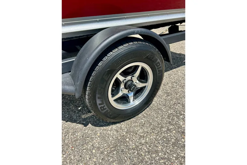Slide: The Image of Trailer wheel of 2019 Alumacraft Classic 165 Sport boat on asphalt surface. - 26