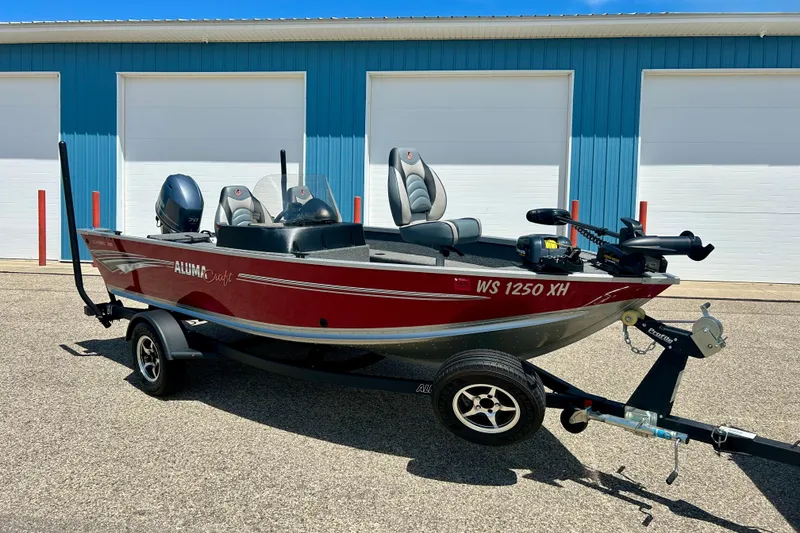 Slide: The Image of 2019 Alumacraft Classic 165 Sport boat on trailer, parked in front of blue garage doors. - 3