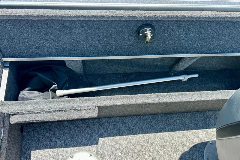 Slide: The Image of Storage compartment in a 2019 Alumacraft Classic 165 Sport boat, featuring a rod holder. - 40