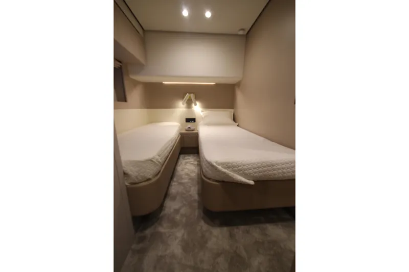 Slide: The Image of 2023 Azimut Fly 68 yacht cabin with twin beds and modern lighting. - 43