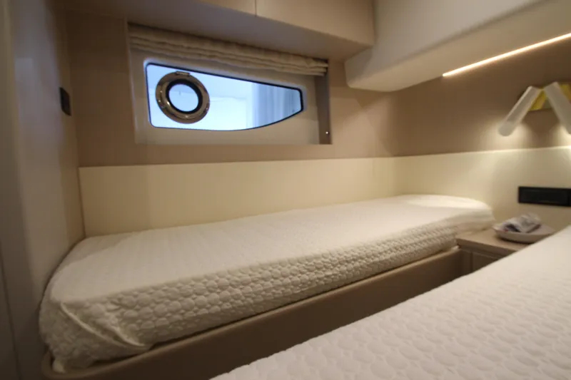 Slide: The Image of Interior cabin of 2023 Azimut Fly 68 yacht with twin beds and porthole window. - 44