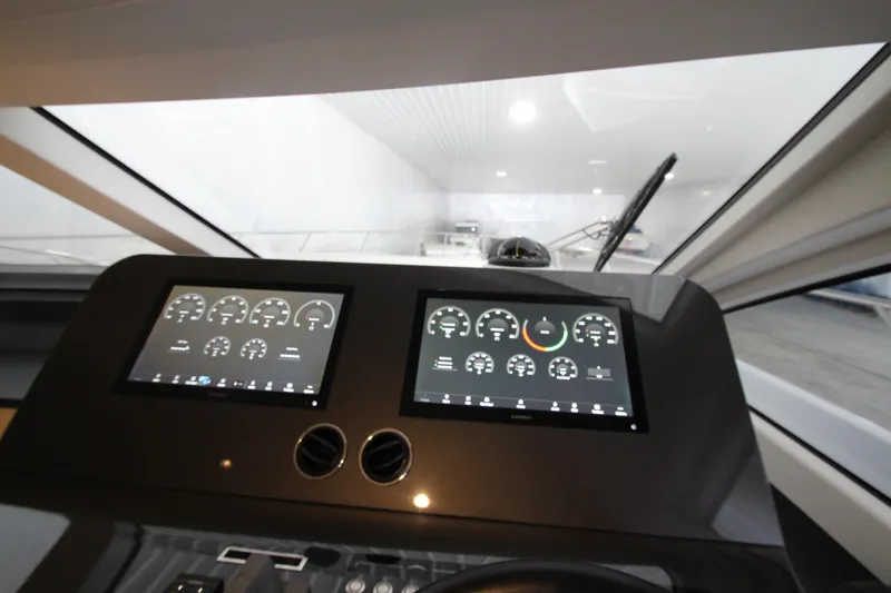 Slide: The Image of 2023 Azimut Fly 68 yacht dashboard with dual digital displays and modern controls. - 30