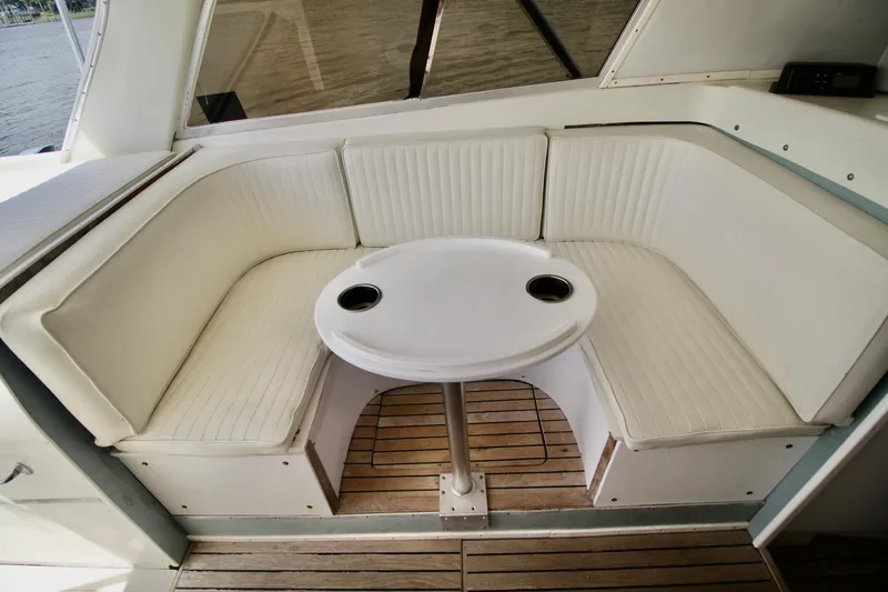 Slide: The Image of 1970 Bertram 31 Sportfisher interior with white seating and round table. - 11