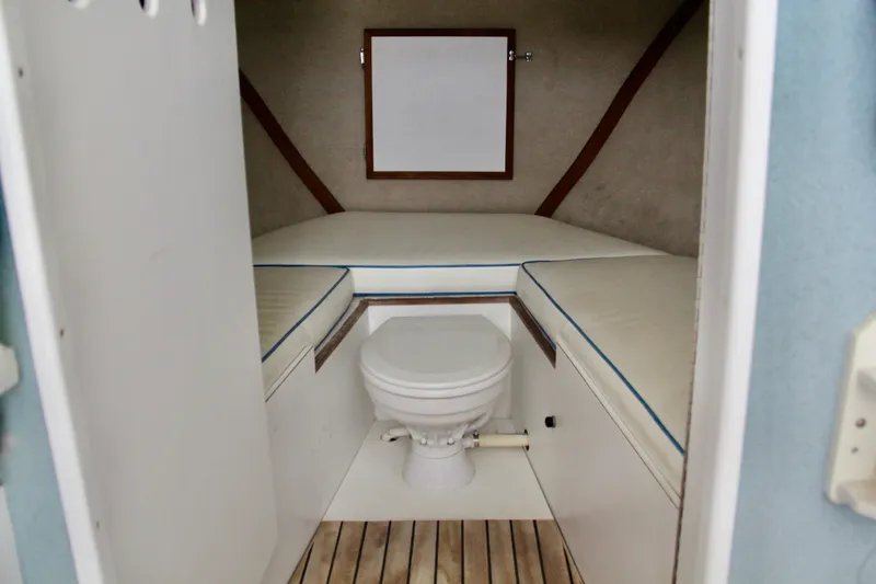 Slide: The Image of 1970 Bertram 31 Sportfisher cabin interior with toilet and cushioned seating. - 15