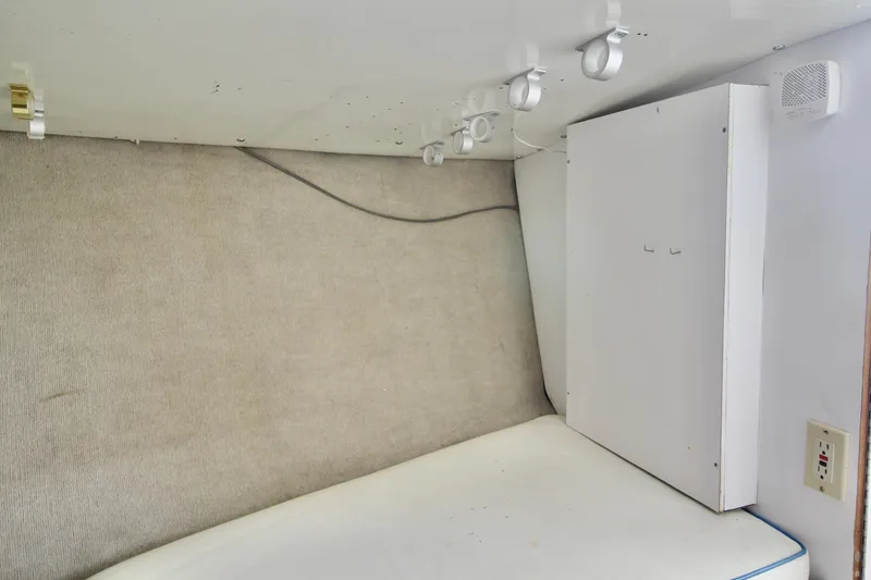 Slide: The Image of Interior cabin of a 1970 Bertram 31 Sportfisher boat with white paneling and lighting fixtures. - 17