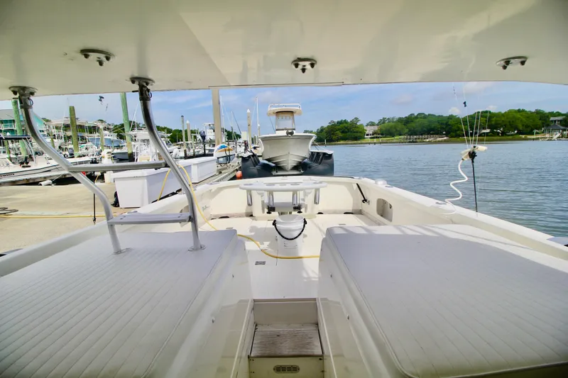 Slide: The Image of 1970 Bertram 31 Sportfisher boat docked at marina, showcasing spacious deck and seating. - 21