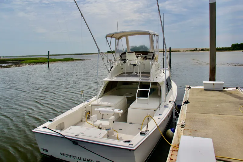 Slide: The Image of 1970 Bertram 31 Sportfisher docked at Wrightsville Beach, NC, under a cloudy sky. - 4