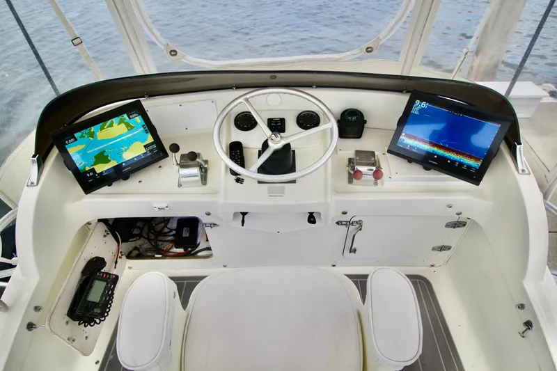 Slide: The Image of Cockpit of a 1970 Bertram 31 Sportfisher with modern navigation equipment and steering wheel. - 7