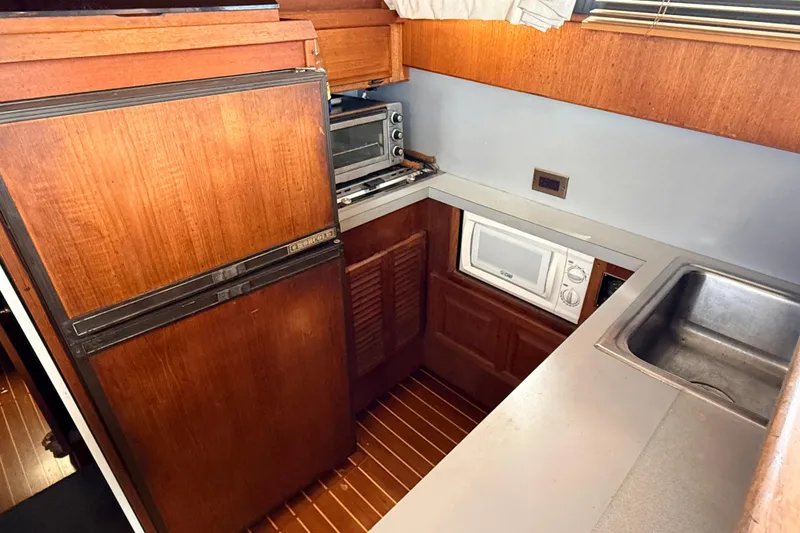 Slide: The Image of Compact kitchen in 1986 Viking 35 Convertible boat with wood cabinetry and appliances. - 13