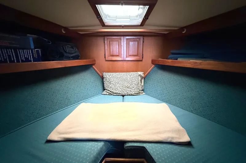 Slide: The Image of Cozy cabin interior of 1986 Viking 35 Convertible yacht with teal bedding and wooden accents. - 18
